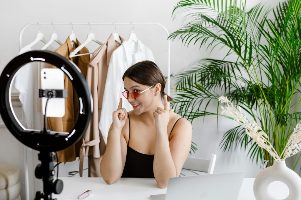 Kampania content marketing – jak skutecznie pozyskiwać klientów i budować widoczność? Kampania content marketing – influencerka nagrywająca wideo przy ring light symbolizująca tworzenie treści wideo i promocję marki w mediach społecznościowych