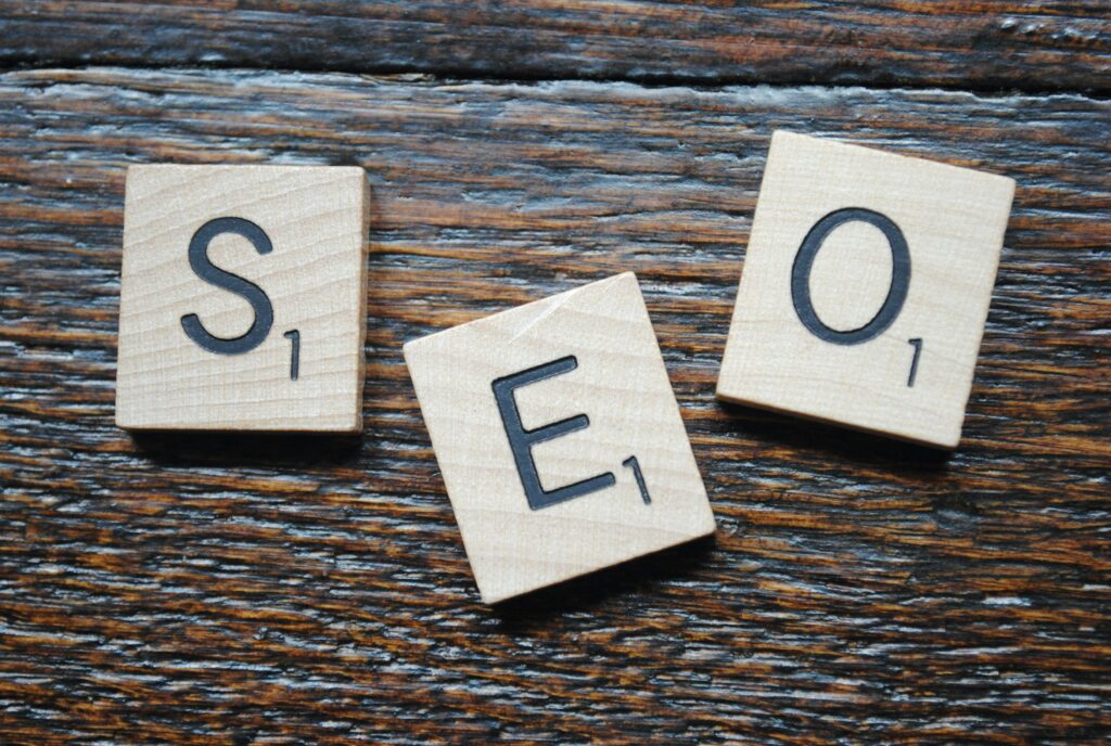 Skuteczne strategie pozycjonowania – jak zdobyć przewagę w Google i zdominować rynek online? Key message – drewniane kostki z literami SEO na rustykalnym tle symbolizujące główny przekaz marketingowy i strategię komunikacji