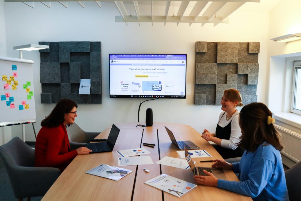 Reklama na LinkedIn – jak skutecznie docierać do decydentów B2B? LinkedIn reklama – zespół omawia kampanię marketingową B2B podczas spotkania przy laptopach w nowoczesnej sali konferencyjnej.