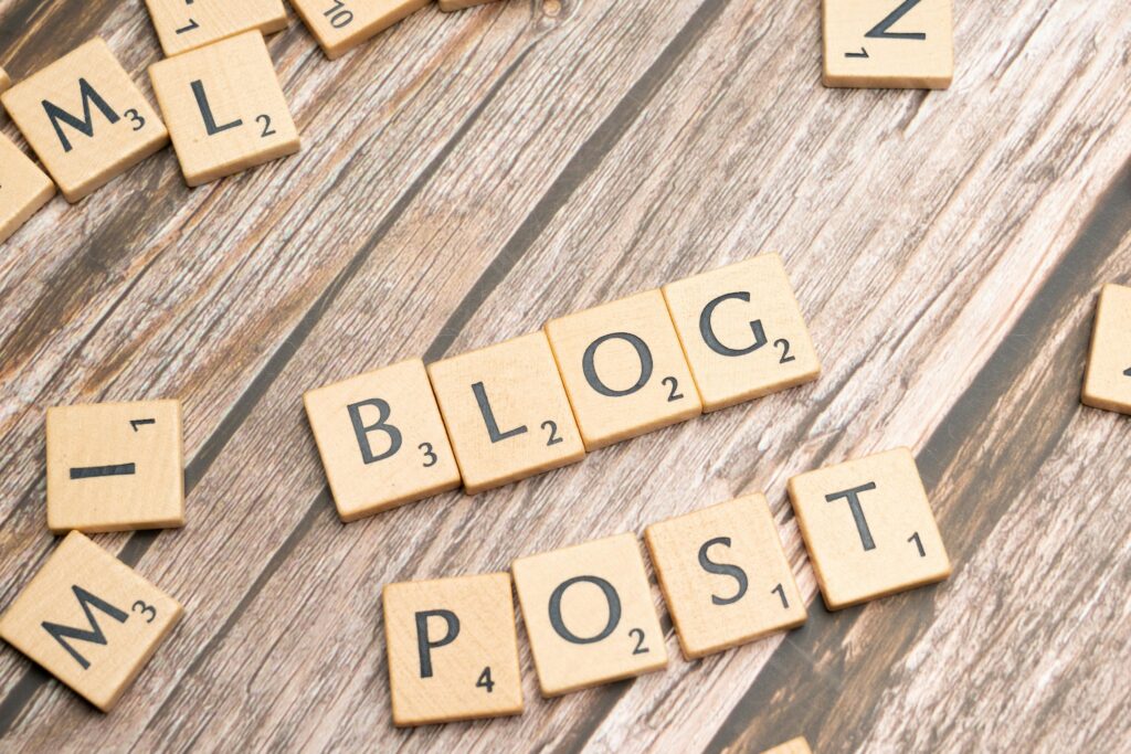 Jak pisać bloga? Praktyczny przewodnik dla początkujących Napis blog post ułożony z drewnianych liter – dobry blog jako narzędzie content marketingu