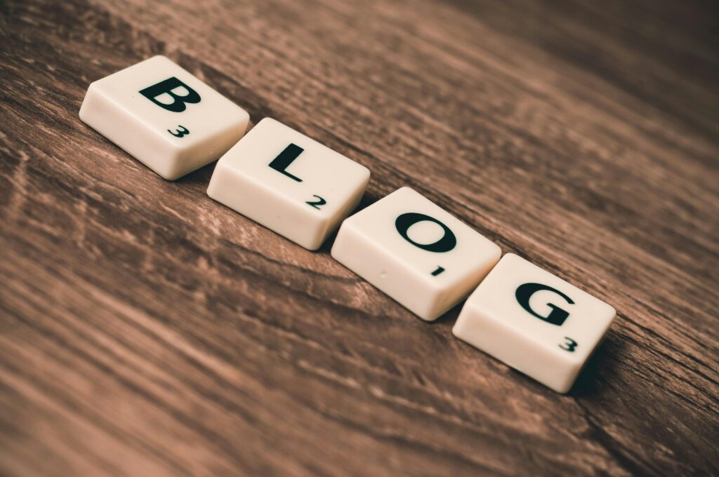 Napis „BLOG” ułożony z liter na drewnianym tle – bloger jako twórca internetowych treści