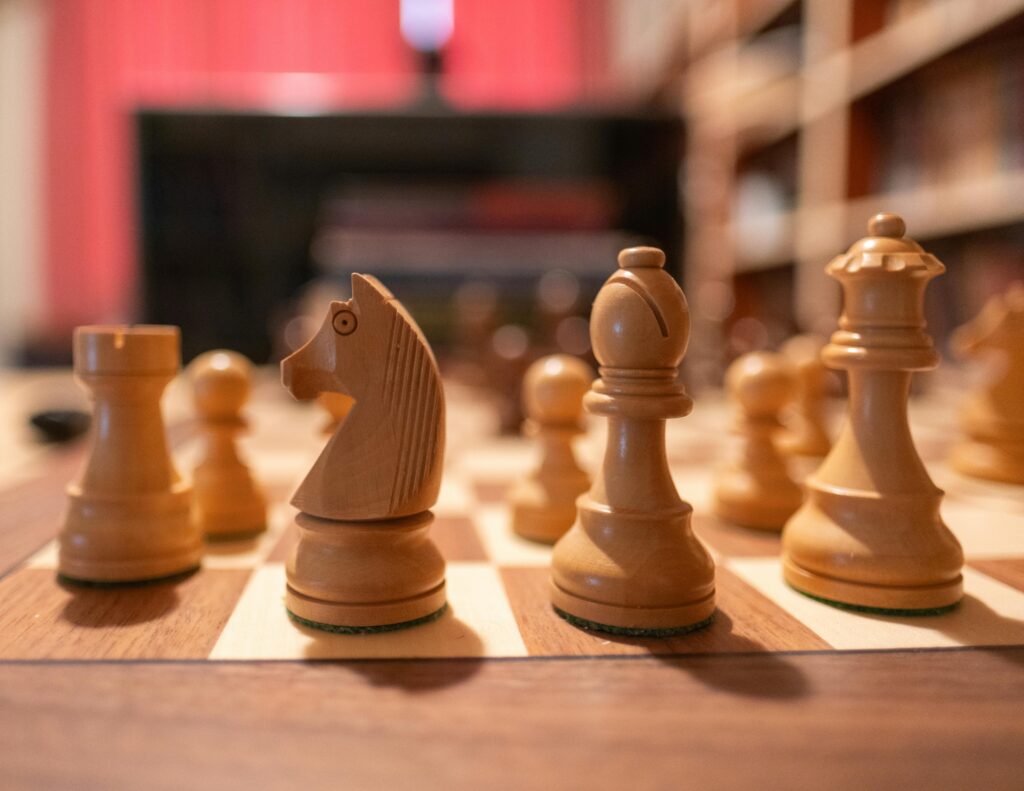 Strategia marketingowa – jak ją stworzyć, aby zdobyć przewagę w internecie? Opracowanie strategii marketingowej – figury szachowe na planszy jako symbol planowania działań, analizy konkurencji i długofalowej strategii marketingowej firmy