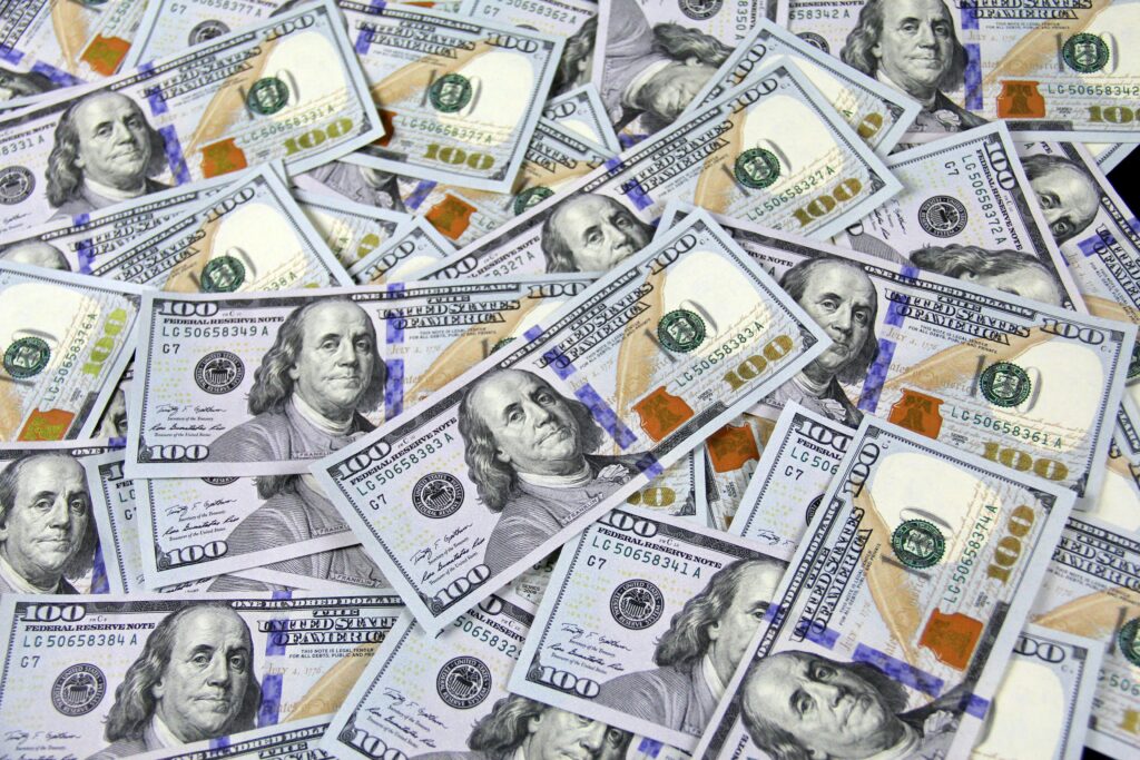 Kolokacja – co to jest i dlaczego jest kluczowa w nauce języków? Kolokacja – rozrzucone banknoty 100 dolarów amerykańskich jako przykład stałego połączenia wyrazów w języku polskim