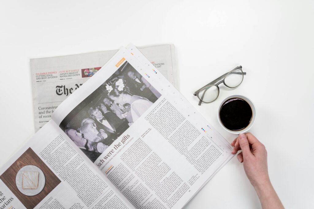 Jak napisać skuteczną informację prasową? Praktyczny przewodnik krok po kroku Gazeta i filiżanka kawy na biurku – jak napisać informację prasową, skuteczny komunikat dla mediów i zasady tworzenia profesjonalnego press release
