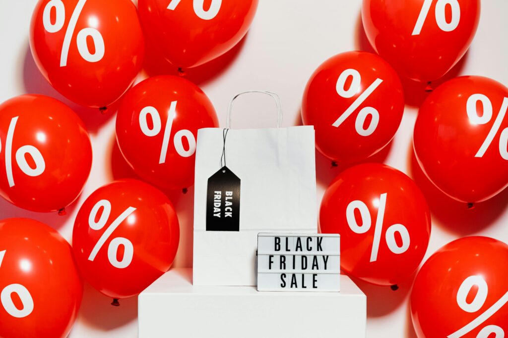 Promocja w marketingu – co to jest i jak skutecznie ją wykorzystać? Promocja co to – wyprzedaż Black Friday z rabatami procentowymi i torbą zakupową symbolizującą obniżki cen i ofertę specjalną