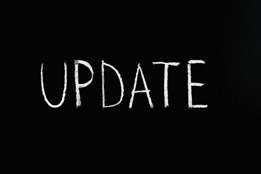 Napis „UPDATE” kredą na czarnym tle – brief Google Ads jako aktualizacja strategii kampanii, określenie celów reklamowych i precyzyjne wytyczne do skutecznej promocji online.