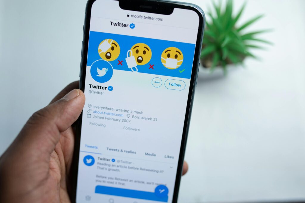 Smartfon z otwartą aplikacją Twitter – jak używać Twittera do budowania marki osobistej, publikowania tweetów, zdobywania obserwujących i prowadzenia skutecznej komunikacji w social media.