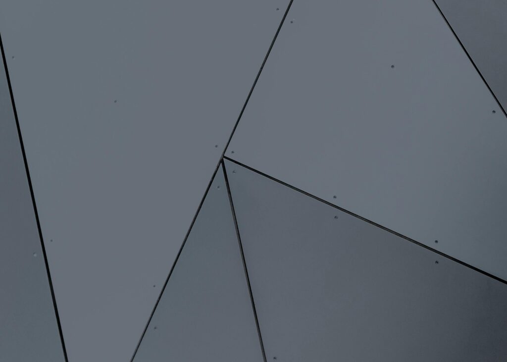 Abstrakcyjna, geometryczna kompozycja ciemnych paneli – minimalistyczne tło symbolizujące odważne i nieszablonowe kampanie typu shockvertising przyciągające uwagę odbiorców.