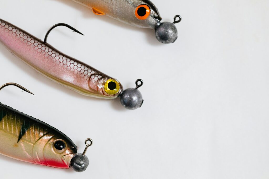 Link baiting – jak zdobywać naturalne linki i wzmacniać SEO? Link baiting – kolorowe przynęty wędkarskie z haczykami jako metafora strategii marketingowej przyciągającej linki i uwagę użytkowników online
