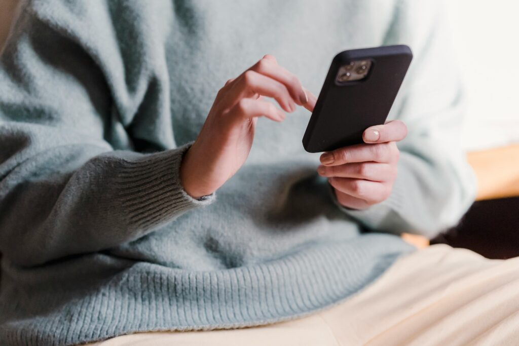 SMS marketing – jak skutecznie zwiększać sprzedaż i budować relacje z klientami? SMS marketing – osoba korzystająca ze smartfona wysyłająca wiadomości tekstowe w kampanii marketingowej mobile