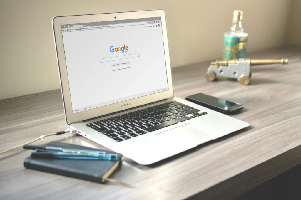 Słowa kluczowe Google – jak je dobierać i skutecznie wykorzystywać w SEO? Laptop z otwartą wyszukiwarką Google na ekranie stojący na biurku – analiza słów kluczowych Google i SEO