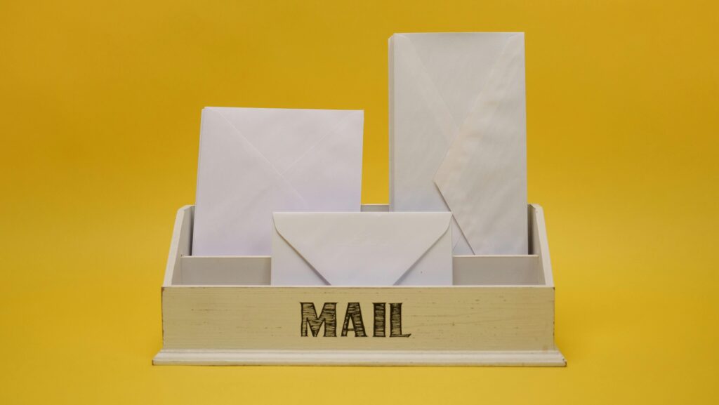 Spam e-mail – jak skutecznie ograniczyć niechciane wiadomości? Spam e-mail – koperty w skrzynce pocztowej symbolizujące niechciane wiadomości i masową wysyłkę maili marketingowych