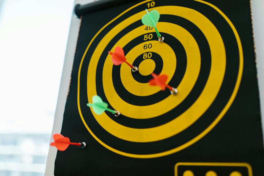 Targetowanie w marketingu – co to jest i jak zwiększa skuteczność kampanii? Targetowanie co to – tarcza z lotkami w centrum symbolizująca precyzyjne kierowanie reklam do określonej grupy odbiorców