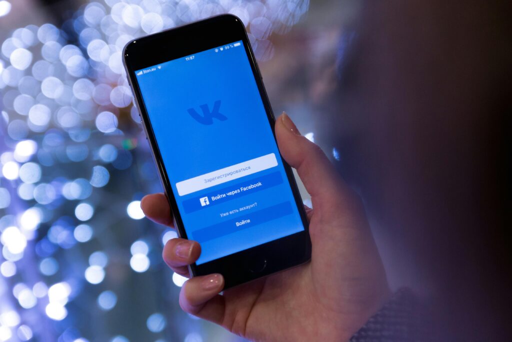 Smartfon z aplikacją społecznościową na ekranie – co to jest Pixel Facebook, czyli narzędzie analityczne do śledzenia konwersji, optymalizacji kampanii reklamowych i remarketingu w Meta Ads.